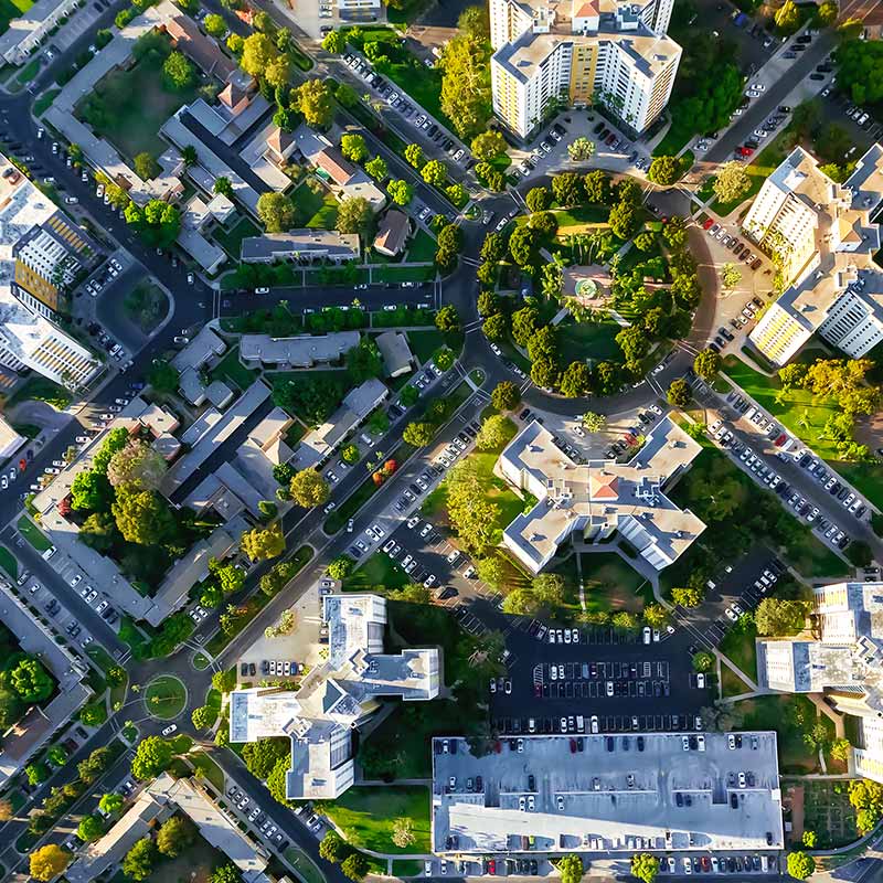 An aerial photo for an urban multi-family development, surrounding a circular park. 